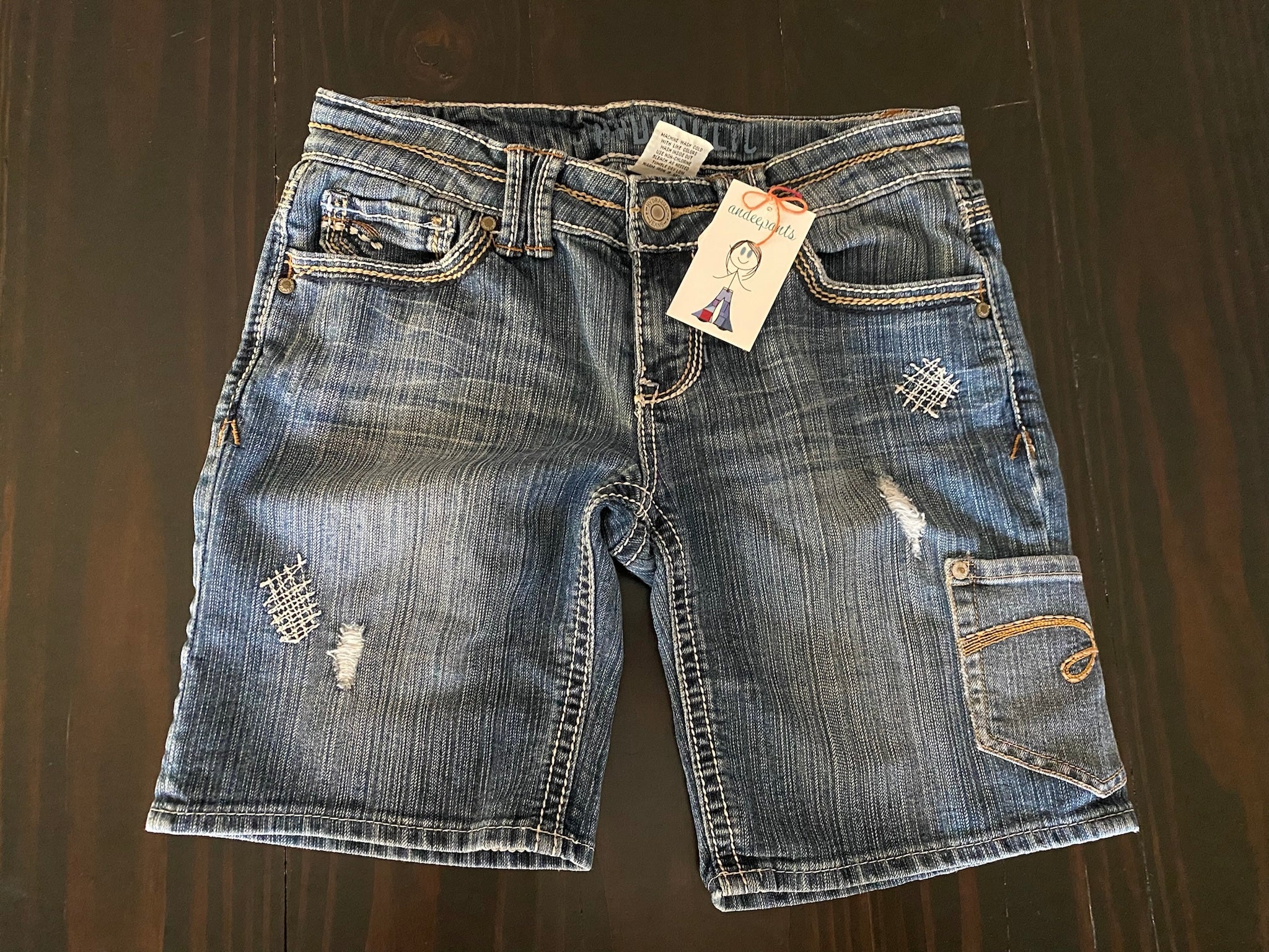 ladies shorts with a blue pocket and yellow flower patch. Size 9/10